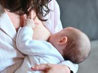 mother holding baby to breast for feeding